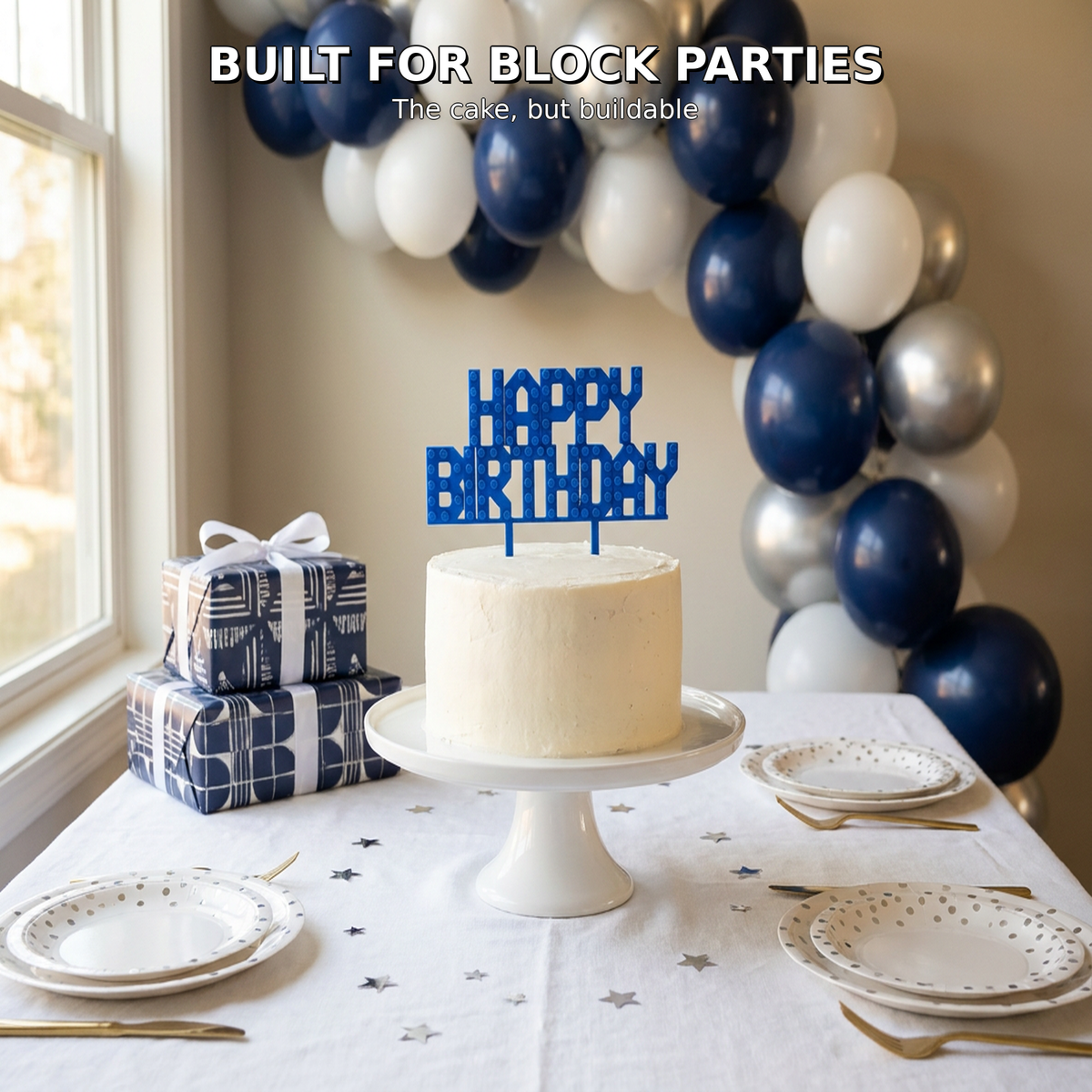 Blue Happy Birthday brick cake topper on a styled navy and white kids birthday party table with balloons and gifts